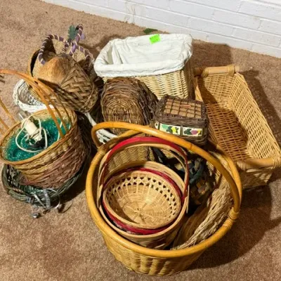 Sale Photo Thumbnail #340: Collection of assorted woven baskets in various shapes, sizes, and natural finishes arranged on a carpeted floor.