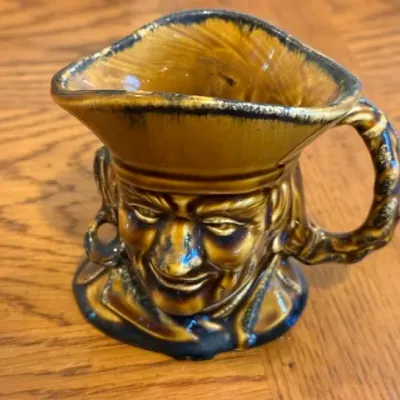 Sale Photo Thumbnail #32: Vintage ceramic pirate character pitcher or creamer in a brown and yellow drip glaze finish.