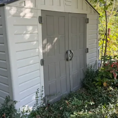 Sale Photo Thumbnail #490: Large outdoor resin storage shed featuring double panel doors with large handles and padlock latch.