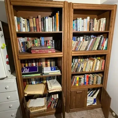 Sale Photo Thumbnail #358: Pair of vintage oak wood bookcases filled with assorted books, papers, and media, featuring lower storage cabinets.