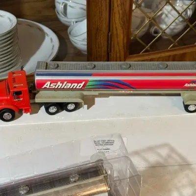 Sale Photo Thumbnail #102: Vintage toy Ashland semi-truck tanker featuring a red cab and silver tanker body, displayed on its original box.