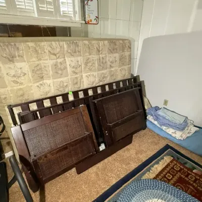 Sale Photo Thumbnail #349: Disassembled dark wood bed frame with woven wicker headboard and footboard panels, accompanied by a patterned mattress.