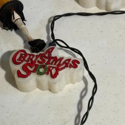 Sale Photo Thumbnail #411: Novelty "A Christmas Story" string light set featuring leg lamps and logo light covers.