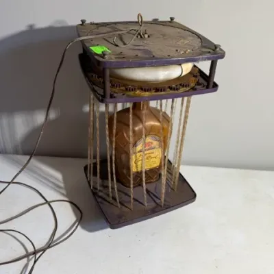 Sale Photo Thumbnail #406: Vintage Seagram's Crown Royal illuminated rain lamp bar display featuring a central bottle replica inside a purple frame with hanging filament strands.
