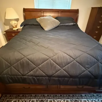 Sale Photo Thumbnail #157: Traditional wooden sleigh bed frame with built-in under-bed storage drawers, flanked by matching nightstands and a tall dresser.