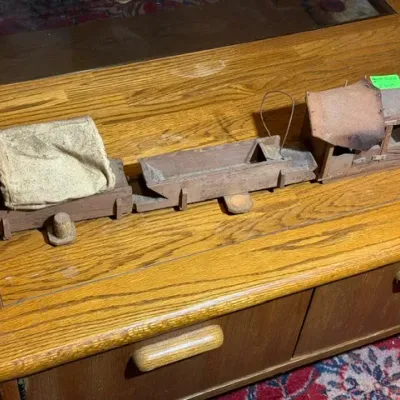 Sale Photo Thumbnail #264: Handmade vintage wooden toy train with fabric accents, showing heavy wear and age-related distressing.