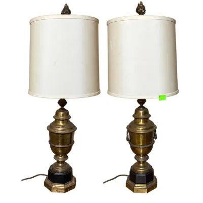 Sale Photo Thumbnail #147: Pair of Neoclassical style brass urn-form table lamps with flame finials, black pedestal bases, and off-white drum shades.
