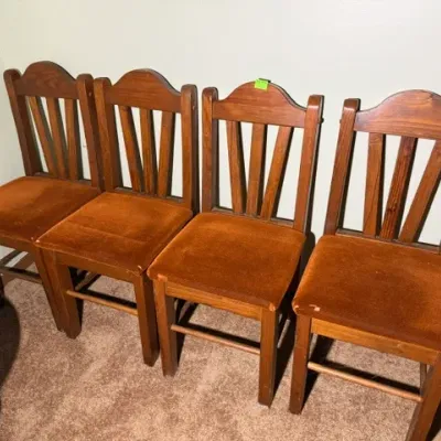 Sale Photo Thumbnail #327: Set of four rustic wooden dining chairs featuring arched sunburst-slat backs and rust-colored upholstered seats.