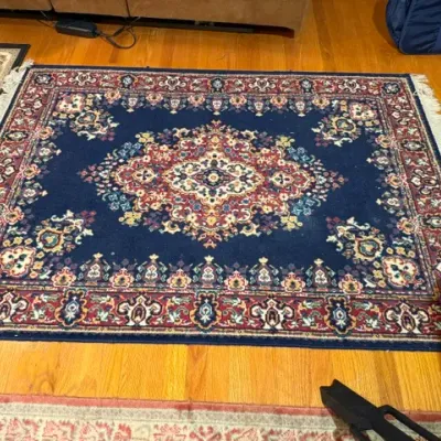 Sale Photo Thumbnail #116: Traditional Persian-style area rug featuring a central medallion motif on a deep navy blue field with a red ornate border.