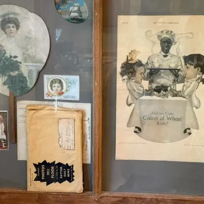 Sale Photo Thumbnail #304: Framed collection of early 20th-century ephemera, including a vintage Cream of Wheat advertisement from The Youth's Companion, an antique hand fan, trade cards, and a 1913 Dayton Daily News flood souvenir photograph envelope.