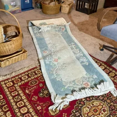 Sale Photo Thumbnail #352: Vintage Chinese Nichols-style wool runner rug with floral pattern in pastel blue and cream, laid atop a red patterned area rug near woven baskets.