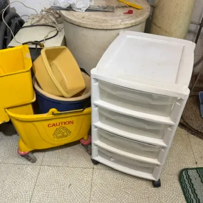 Sale Photo Thumbnail #392: Yellow commercial mop bucket with wringer alongside a white plastic four-drawer rolling storage cart.