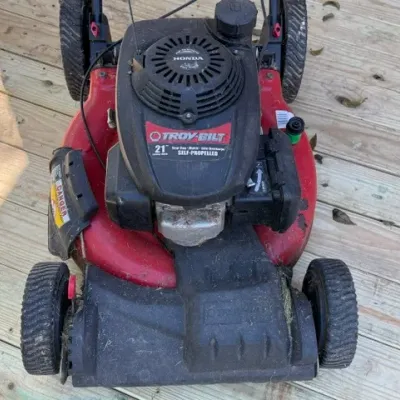 Sale Photo Thumbnail #199: Troy-Bilt 21-inch self-propelled lawn mower with a Honda engine, showing minor wear and dirt from use.