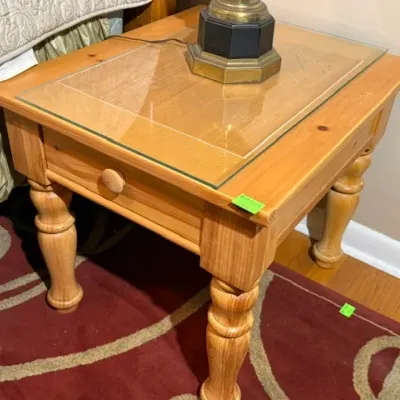 Sale Photo Thumbnail #145: Traditional solid light-stained pine nightstand featuring turned legs, a single pull drawer, and a protective glass top insert.