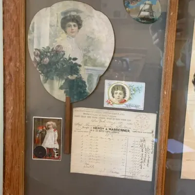 Sale Photo Thumbnail #305: Framed collection of antique paper ephemera, including an early 20th-century hand fan, Victorian trade cards, and an 1886 handwritten receipt.