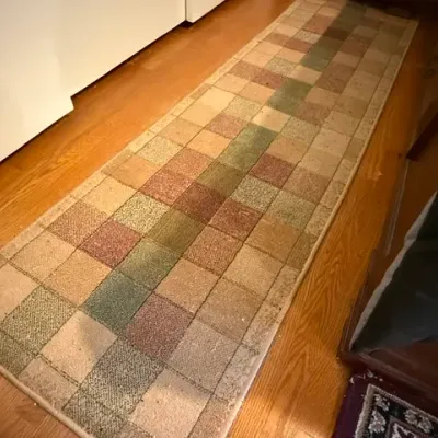 Sale Photo Thumbnail #169: Woven hallway runner rug featuring a geometric patchwork grid design in muted earth tones of green, brown, and tan.