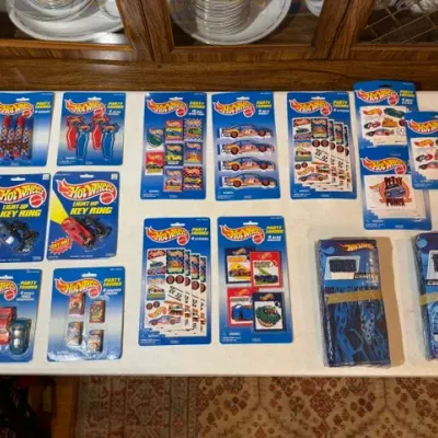 Sale Photo Thumbnail #94: Vintage Hot Wheels themed party favors and novelty items in original blister packaging, including key rings, pencil sharpeners, stickers, and favors.