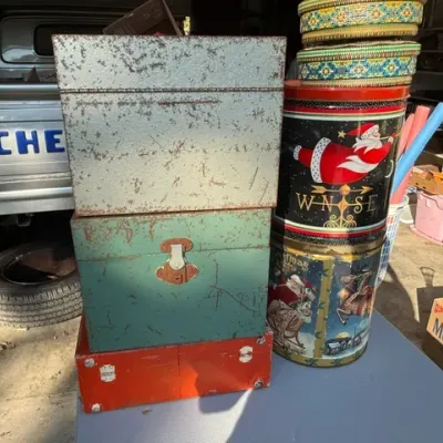 Sale Photo Thumbnail #453: Assortment of vintage metal boxes and decorative Christmas tins showing surface wear and patina.