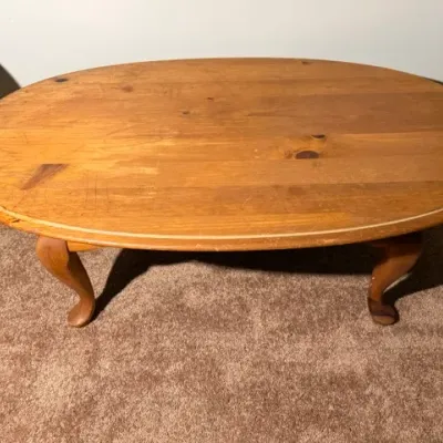 Sale Photo Thumbnail #323: Vintage oval pine coffee table featuring curved cabriole legs and a warm natural wood finish, showing some surface scratches from use.