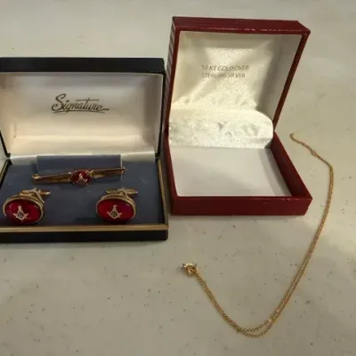 Sale Photo Thumbnail #66: Masonic cufflinks and tie clip set in a Signature display box alongside a fine gold-toned chain necklace with its 18kt gold over sterling silver box.