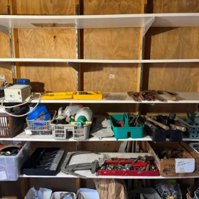 Sale Photo Thumbnail #208: Garage workshop wall shelving filled with an assortment of hand tools, hardware, storage caddies, and workshop supplies.