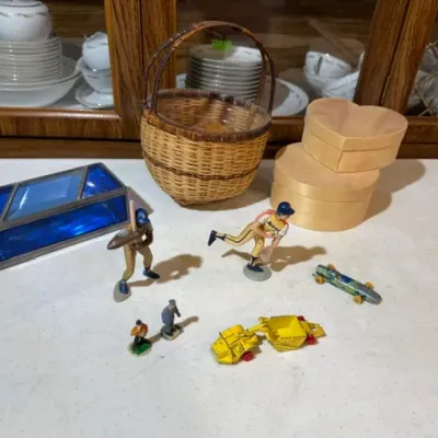 Sale Photo Thumbnail #114: Assortment of vintage collectibles, including a blue stained glass trinket box, woven basket, heart-shaped bentwood boxes, plastic baseball figurines, and die-cast toy vehicles.
