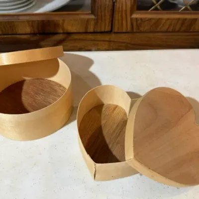 Sale Photo Thumbnail #115: Two handmade bentwood Shaker-style boxes with fitted lids, including one oval and one heart-shaped design.