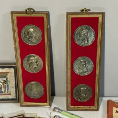 Sale Photo Thumbnail #428: Pair of vintage framed US Presidents commemorative coin wall plaques set on red velvet matting, featured alongside a framed Egyptian papyrus art piece.