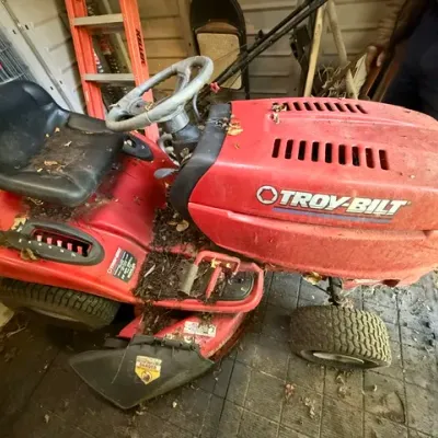 Sale Photo Thumbnail #279: Red Troy-Bilt riding lawn mower showing surface dirt and debris, stored inside a shed.