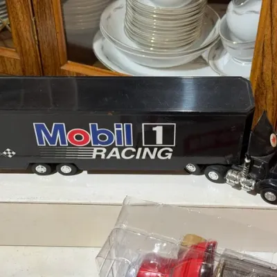 Sale Photo Thumbnail #103: Black Mobil 1 Racing toy semi-truck and trailer, sitting atop its white cardboard box.