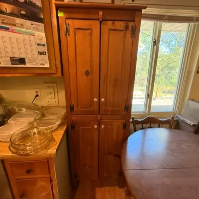 Sale Photo Thumbnail #301: Rustic tall pine jelly cupboard featuring four raised-panel doors, black strap hinges, and white ceramic knobs.