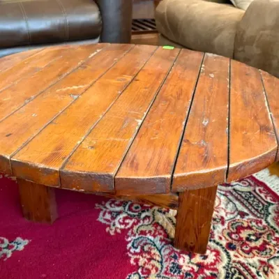 Sale Photo Thumbnail #47: Rustic round slatted-top wooden coffee table with block legs, featuring visible surface wear and a distressed finish.