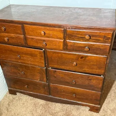 Sale Photo Thumbnail #345: Vintage dark stain wooden dresser featuring twelve drawers with matching wooden knobs and showing light surface wear.