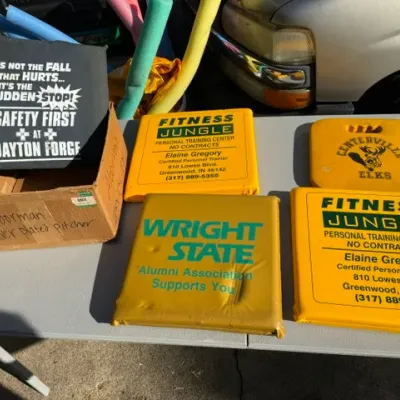 Sale Photo Thumbnail #443: Collection of vintage promotional foam stadium cushions featuring various business logos and school branding, including Fitness Jungle and Wright State.