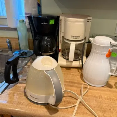 Sale Photo Thumbnail #314: Selection of small kitchen counter appliances including two Mr. Coffee drip coffee makers, a Proctor Silex electric kettle, an extra coffee carafe, and a white insulated thermal carafe.