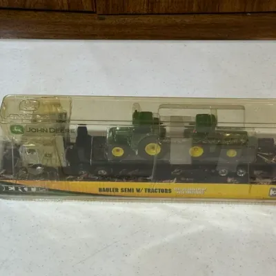 Sale Photo Thumbnail #96: Vintage ERTL John Deere Hauler Semi with Tractors set, unopened in its original plastic blister packaging.