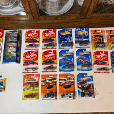 Sale Photo Thumbnail #93: Collection of unopened Hot Wheels and Matchbox die-cast toy cars in original blister pack and box packaging.