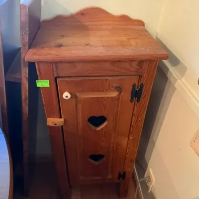 Sale Photo Thumbnail #307: Rustic pine narrow storage cabinet featuring a single door with heart cutout accents, black H-hinges, and a wood turn latch.