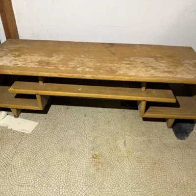 Sale Photo Thumbnail #378: Mid-century modern wooden low-profile coffee table or media console with an asymmetrical floating center shelf and tapered feet, showing heavy finish wear on the top surface.