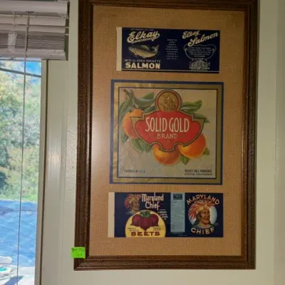 Sale Photo Thumbnail #310: Framed vintage label collection featuring Elkay Salmon, Solid Gold Brand fruit crate, and Maryland Chief Beets labels presented under glass with a textured mat in a dark wood frame.