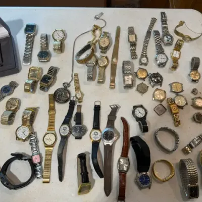 Sale Photo Thumbnail #61: Large collection of assorted men's and women's vintage wristwatches, pocket watches, and watch bands displayed on a table surface.