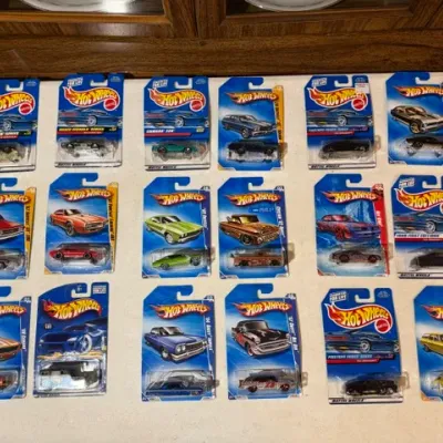 Sale Photo Thumbnail #89: Collection of 18 packaged Hot Wheels die-cast cars from the late 1990s and early 2000s, including various First Editions and series models in original blister cards.
