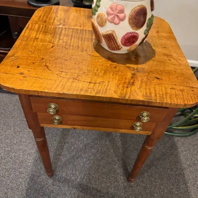 Sale Photo Thumbnail #32: Antique tiger maple stand with two drawers and brass hardware, topped with a vintage ceramic cookie jar.