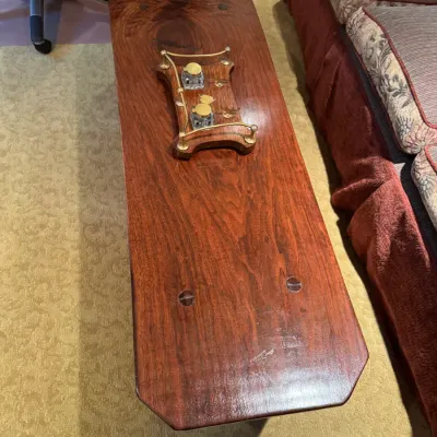 Sale Photo Thumbnail #70: Rustic solid wood coffee table with a polished finish and exposed joinery details, topped with an antique wooden inkstand featuring dual glass inkwells and brass gallery railing.