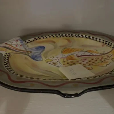 Sale Photo Thumbnail #40: Hand-painted ceramic fish platter featuring a whimsical aquatic design with checkered rim details.