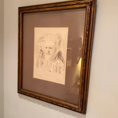 Sale Photo Thumbnail #77: Framed Salvador Dalí pencil-signed etching depicting Sigmund Freud, presented in a ornate carved gilt wood frame with wide matting.