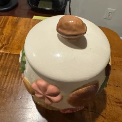 Sale Photo Thumbnail #31: Vintage ceramic cookie jar featuring raised cookie motifs around the base and a walnut-shaped lid handle, showing light surface crazing.
