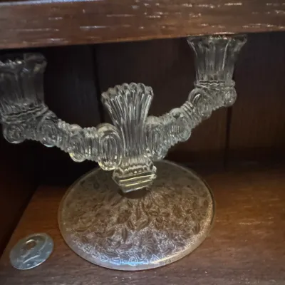 Sale Photo Thumbnail #21: Vintage double-arm clear pressed glass candelabra with an ornate floral pattern on the round base.