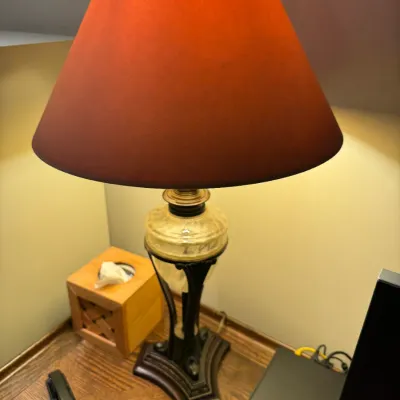 Sale Photo Thumbnail #72: Vintage table lamp featuring a dark ornate metal base, a translucent alabaster-style glass center, and a large burnt orange conical lampshade.