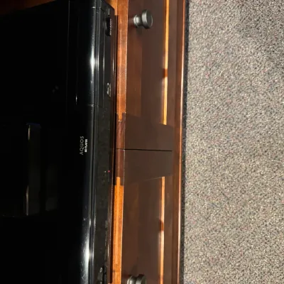 Sale Photo Thumbnail #34: Black Sharp Aquos Blu-ray Disc player resting inside a wooden entertainment media console.